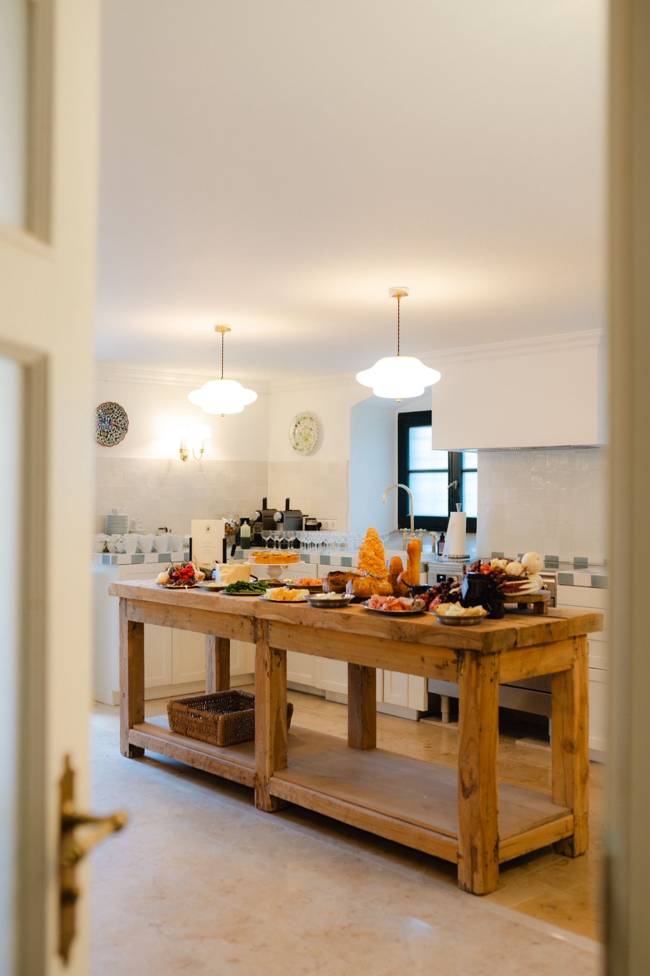 Holzinsel in einer Landhausküche, gedeckt mit Brot, Käse und Früchten