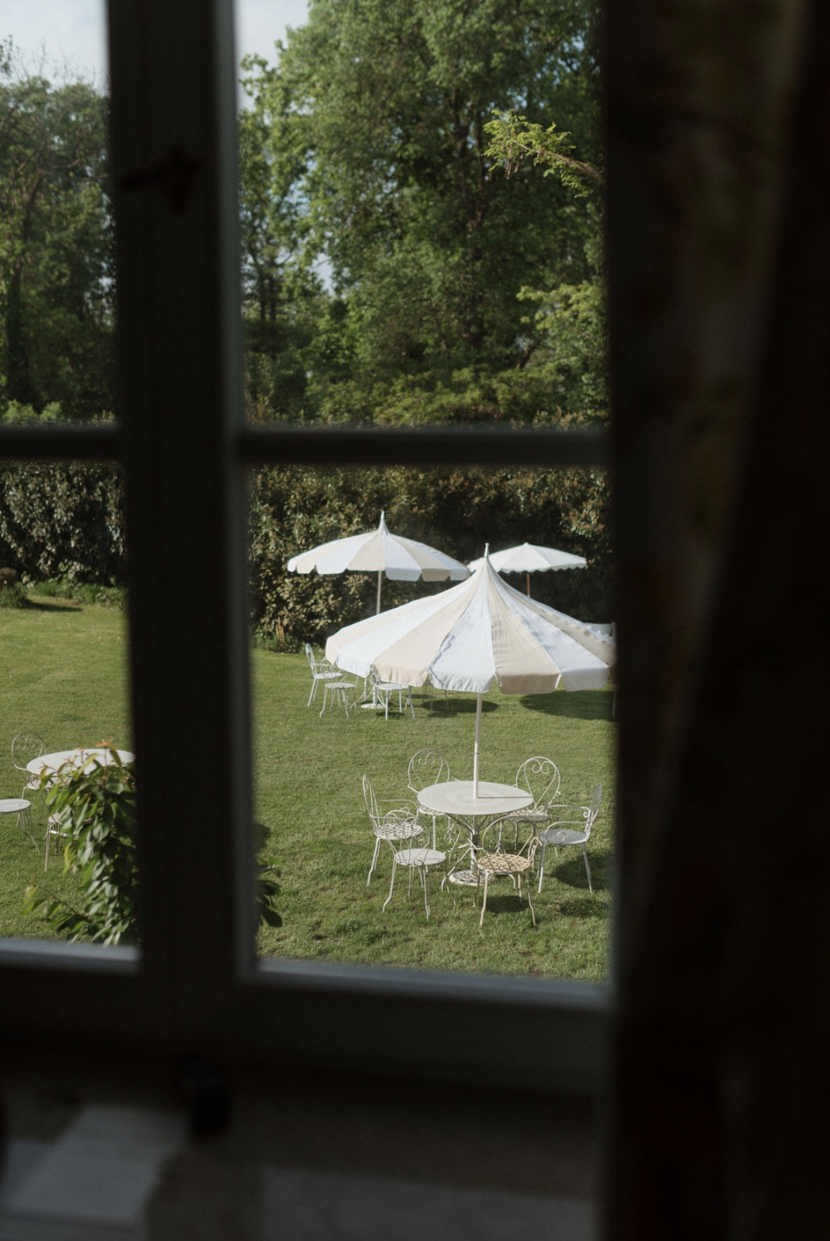 Blick aus dem Fenster der Villa Fuchs auf den Garten mit Sonnenschirmen