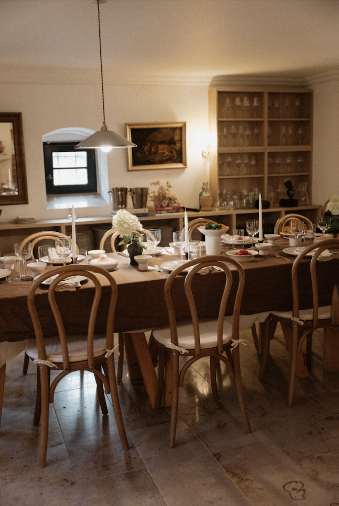 Tafel mit brauner Tischdecke, Kerzen und Bugholzstühlen in der Weinstube